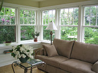 The sunroom, with screened windows all around and a fabulous view, can be used as a third bedroom or as a den